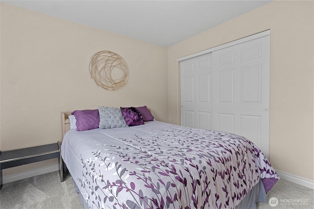 carpeted bedroom featuring baseboards and a closet