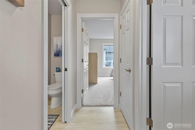 hallway featuring baseboards and light wood-style flooring