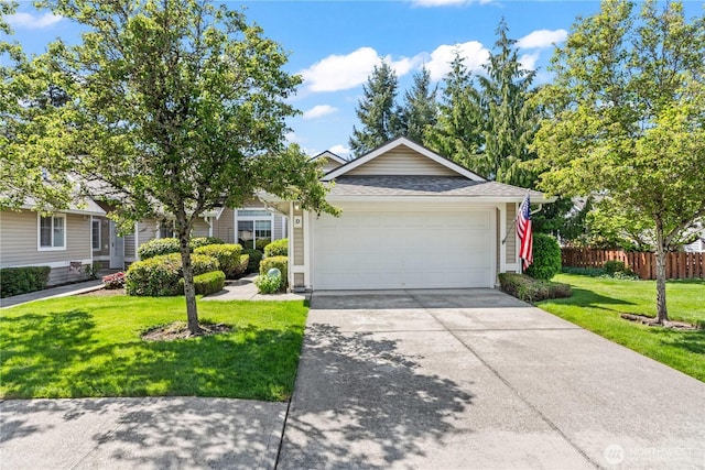 view of front of property with fence, an attached garage, a shingled roof, concrete driveway, and a front yard