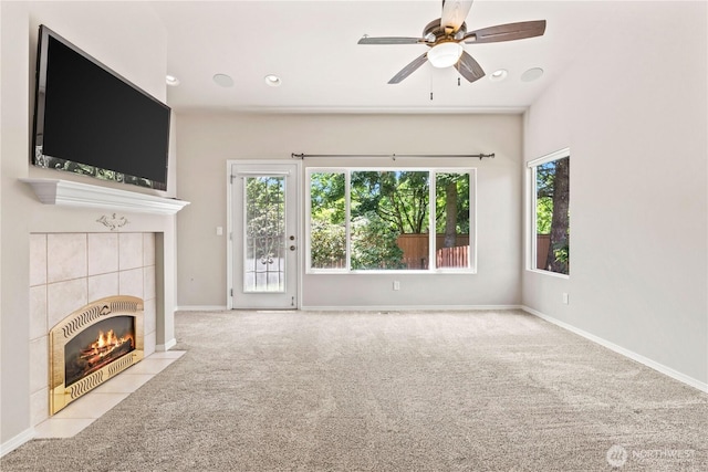 unfurnished living room featuring carpet flooring, a fireplace, baseboards, and ceiling fan