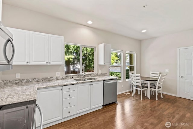 kitchen with white cabinets, appliances with stainless steel finishes, dark wood-style flooring, and a sink