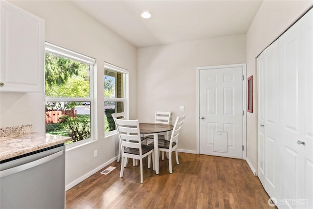 dining room featuring plenty of natural light, wood finished floors, and baseboards