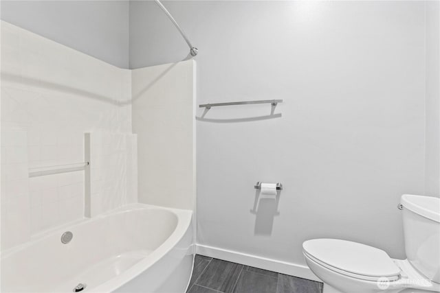 full bath featuring toilet, baseboards, and shower / washtub combination