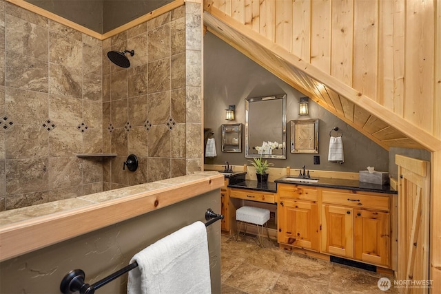 bathroom with vanity and a tile shower