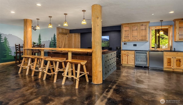 kitchen featuring light brown cabinetry, dark countertops, concrete floors, and beverage cooler
