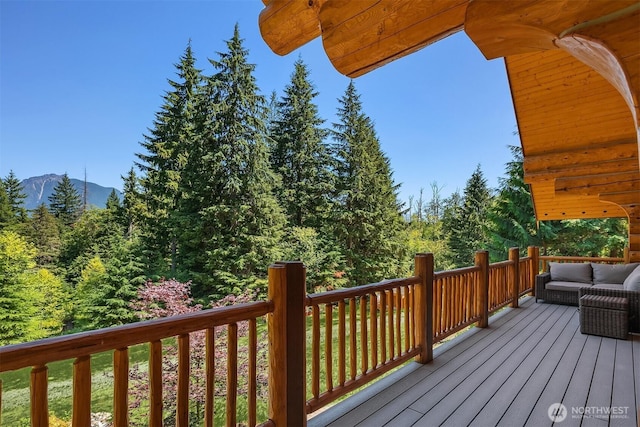 wooden deck featuring a mountain view and an outdoor hangout area