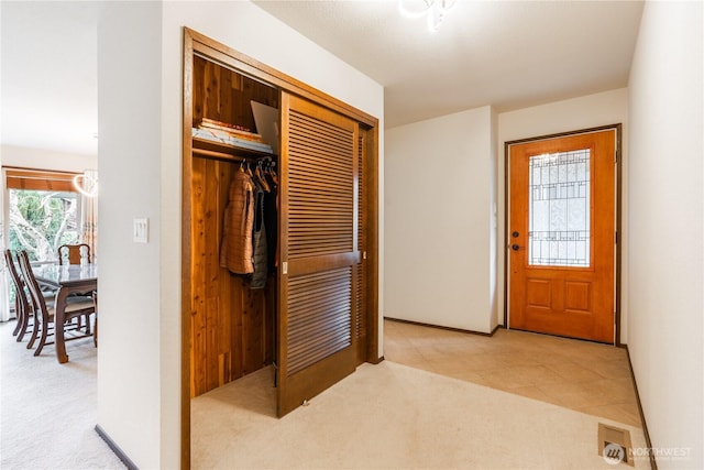 foyer featuring carpet flooring and baseboards
