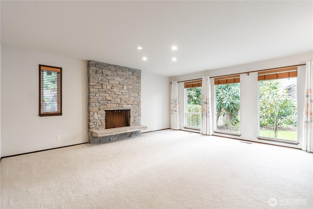 unfurnished living room with carpet flooring, recessed lighting, a healthy amount of sunlight, and a fireplace
