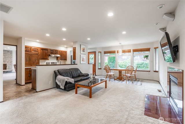 living room with visible vents, recessed lighting, and a fireplace