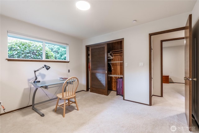 office space with baseboards and light carpet