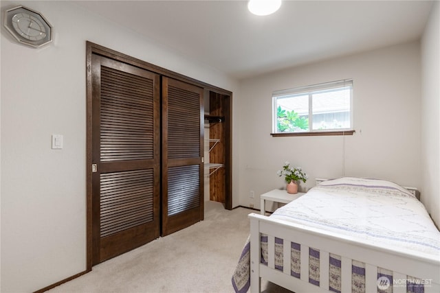 bedroom with light colored carpet and a closet