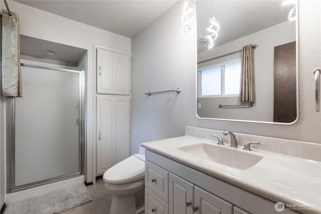full bathroom featuring vanity, tile patterned flooring, a shower stall, and toilet