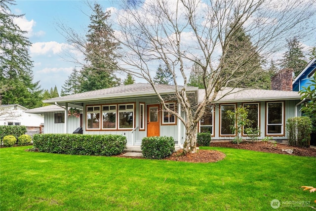 view of front of home featuring a front lawn, board and batten siding, and a chimney