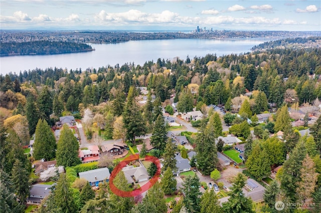 birds eye view of property with a water view, a view of trees, and a residential view