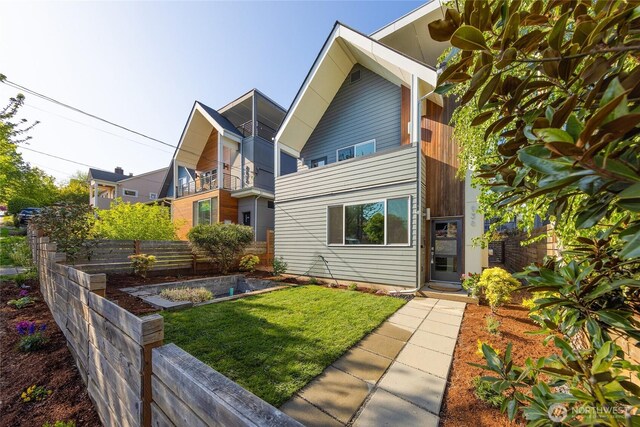 back of house with a yard, a vegetable garden, and fence