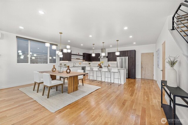 dining room with light wood-style floors, baseboards, and recessed lighting