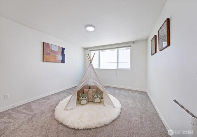 rec room with baseboards and carpet flooring