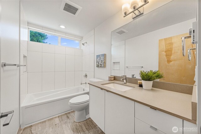 full bathroom with visible vents, shower / tub combination, toilet, and vanity