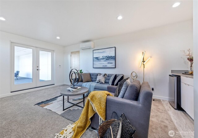 living area with an AC wall unit, recessed lighting, and french doors