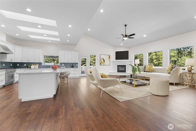 23615 38th Ave E, Spanaway, WA 98387 - living room with dark wood-style flooring, high vaulted ceiling, ceiling fan, recessed lighting, and a glass covered fireplace