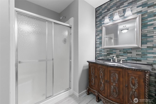 23615 38th Ave E, Spanaway, WA 98387 - bathroom with a stall shower, vanity, baseboards, and wood finished floors
