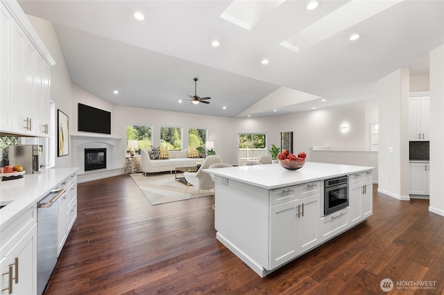 23615 38th Ave E, Spanaway, WA 98387 - kitchen featuring open floor plan, appliances with stainless steel finishes, light countertops, dark wood-style flooring, and white cabinets