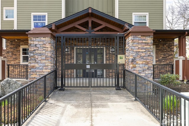 property entrance featuring a gate and stone siding