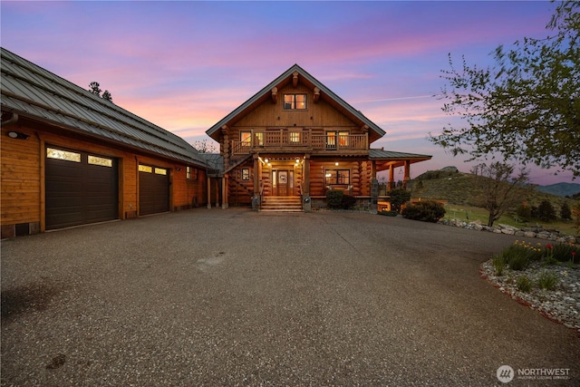 view of front of home featuring a porch, a standing seam roof, metal roof, and aphalt driveway