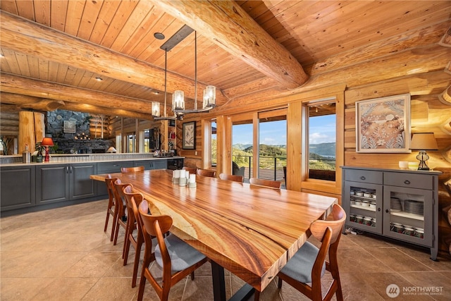 dining room featuring wood ceiling, rustic walls, a mountain view, an inviting chandelier, and light tile patterned flooring