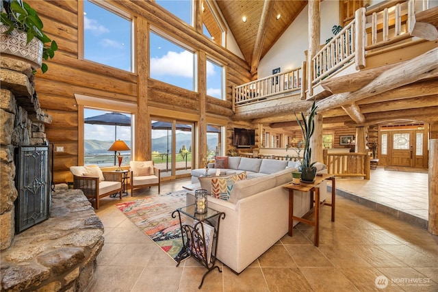 tiled living area with high vaulted ceiling, log walls, and a stone fireplace