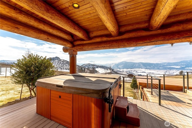 deck with a hot tub and a mountain view