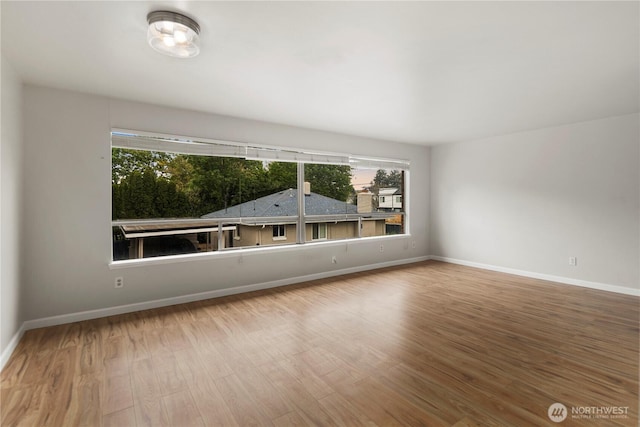 empty room featuring baseboards and wood finished floors