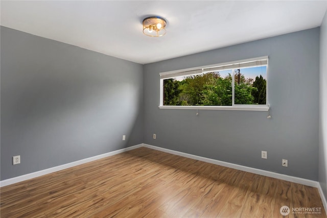 empty room with baseboards and wood finished floors
