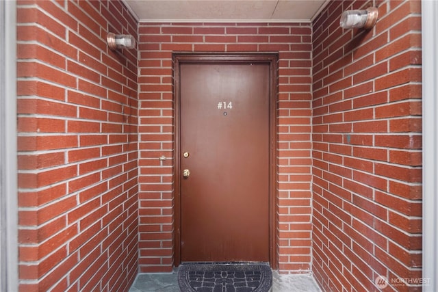 entrance to property featuring brick siding
