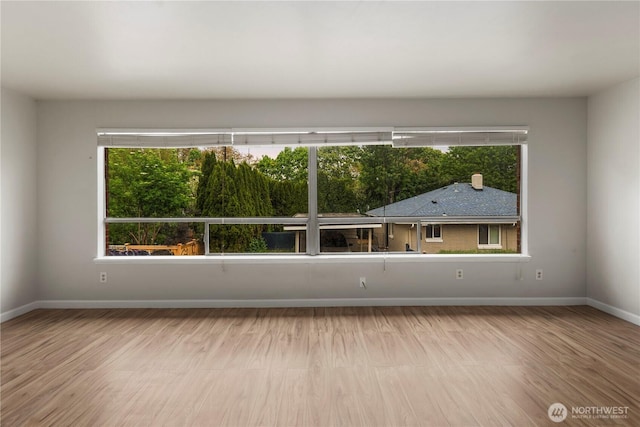 spare room featuring baseboards and wood finished floors