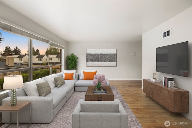 living room featuring baseboards, wood finished floors, and visible vents