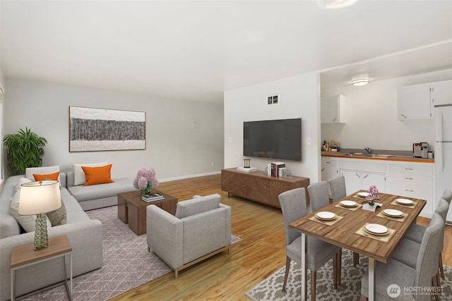 living area featuring visible vents and light wood-style floors