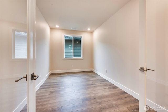 unfurnished room featuring baseboards, recessed lighting, wood finished floors, and visible vents