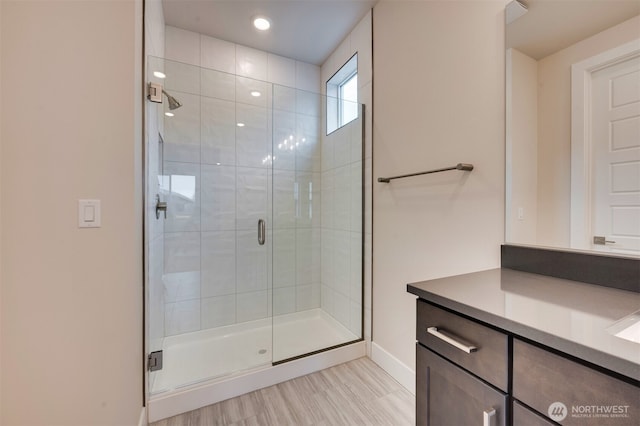 full bath with baseboards, recessed lighting, a stall shower, and vanity