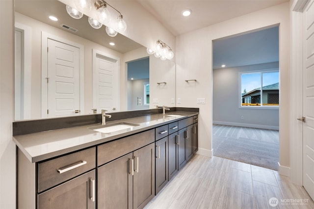 full bathroom with visible vents, a sink, baseboards, and double vanity