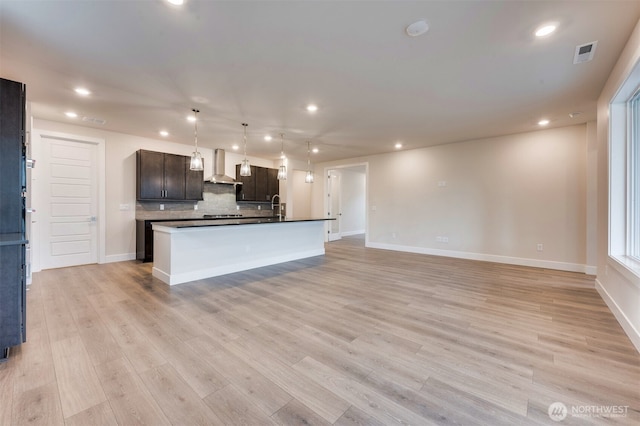 kitchen with recessed lighting, visible vents, decorative backsplash, and wall chimney exhaust hood