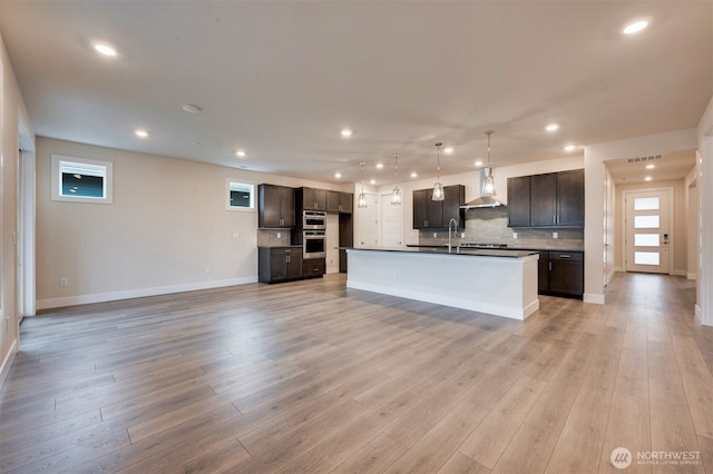kitchen featuring tasteful backsplash, recessed lighting, and wall chimney exhaust hood