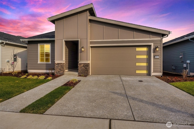 view of front of house with board and batten siding, an attached garage, driveway, and stone siding