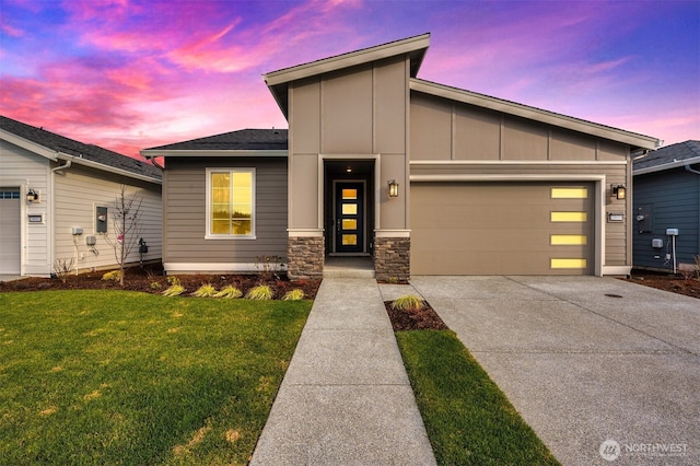view of front of property featuring board and batten siding, driveway, a yard, an attached garage, and stone siding