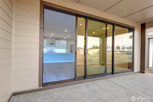 doorway to outside featuring a sink and carpet