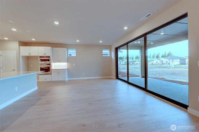 unfurnished living room featuring light wood-style floors, recessed lighting, baseboards, and visible vents
