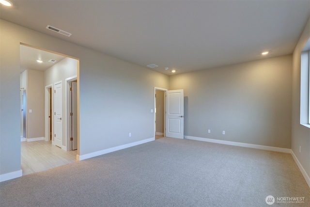 unfurnished room with baseboards, light carpet, recessed lighting, and visible vents