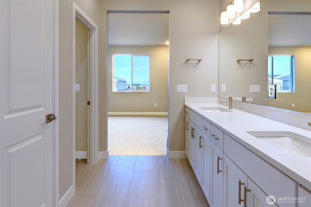 full bath featuring a sink, baseboards, and a wealth of natural light