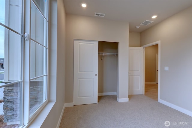 unfurnished bedroom with visible vents, recessed lighting, baseboards, and light colored carpet
