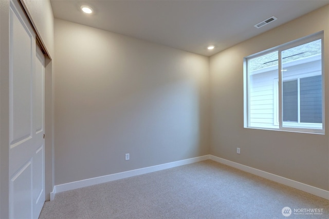 spare room with baseboards, light colored carpet, recessed lighting, and visible vents